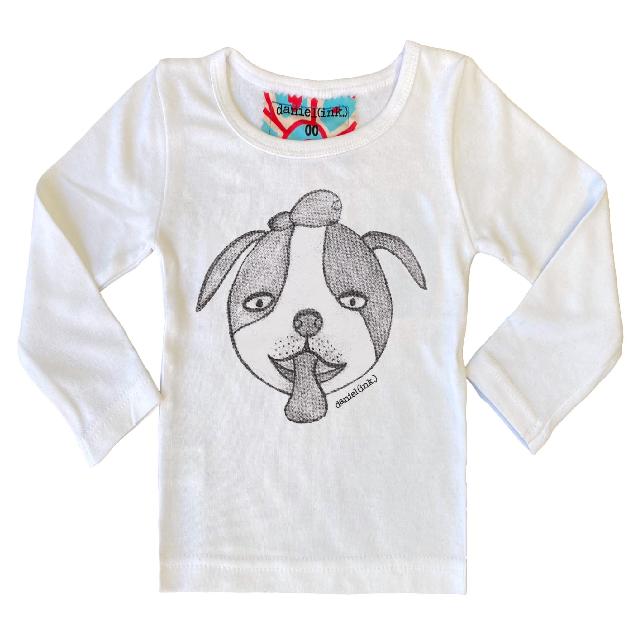 White long sleeve babies’ shirt featuring a hand drawn sketch of a dog’s face in black. The dog has a round head, floppy ears, wide eyes, and its tongue is sticking out. There is also a red, white, and blue fabric label on the back of the neck.