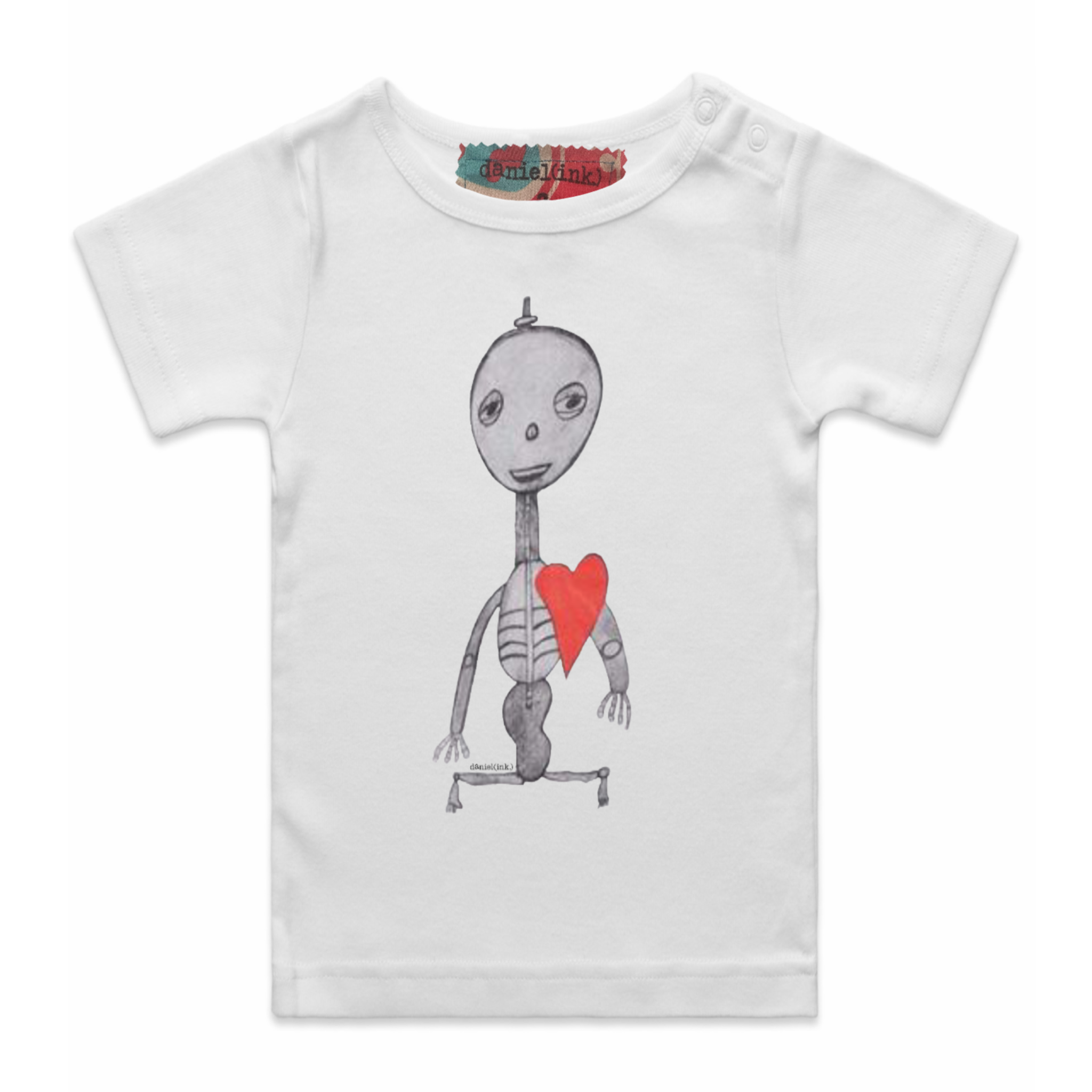 White short sleeve babies’ t-shirt featuring a hand drawn sketch of a skeleton with a red heart. The t-shirt has a red, white, and blue fabric label on the back of the neck and has two white press studs on the left shoulder.
