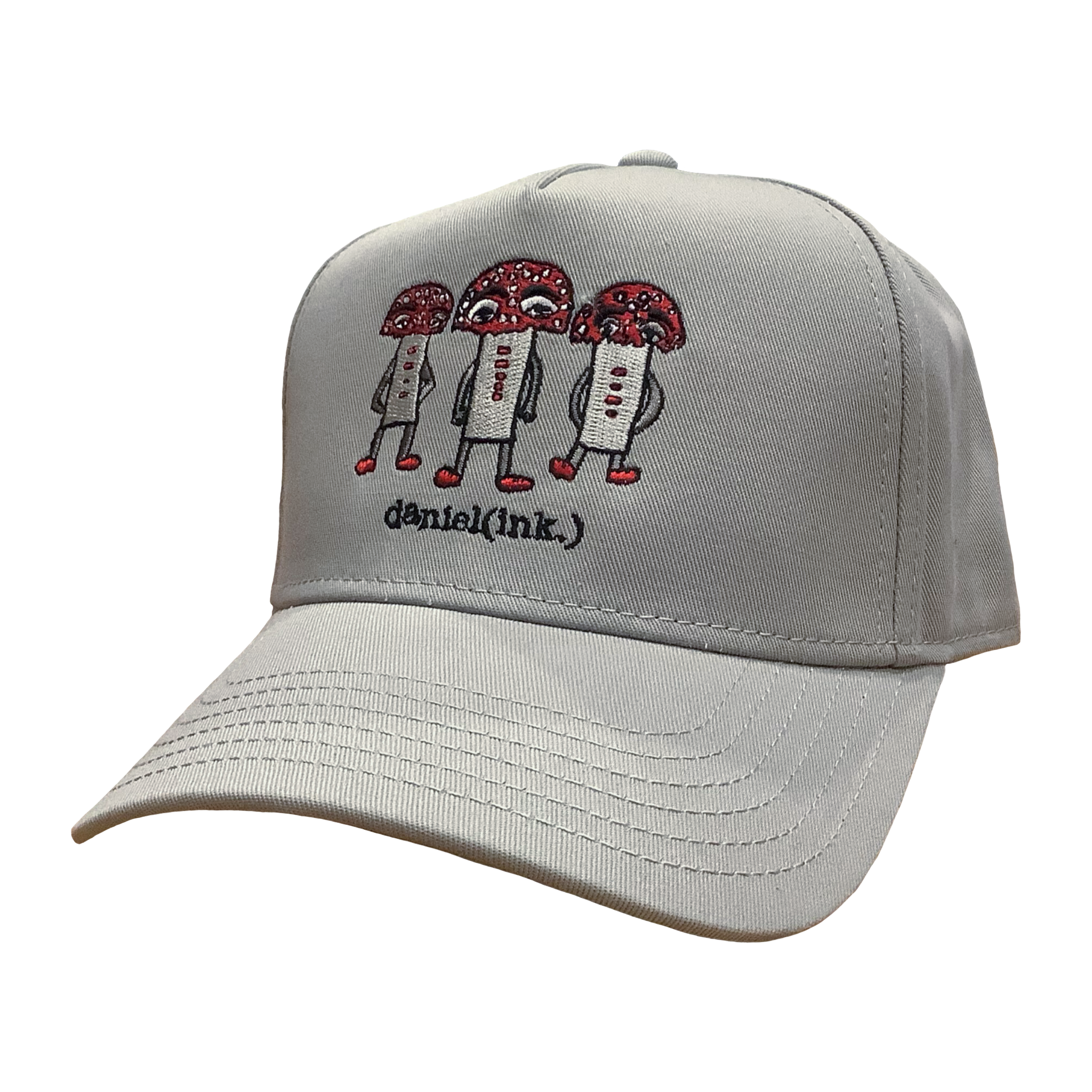 Storm coloured snapback cap featuring an embroidered image of three large mushroom humanoid figures. The mushroom figures have red heads and red shoes and red buttons which spell "magic" in morse code. The name daniel(ink.) is embroidered in black thread underneath the mushroom figures.