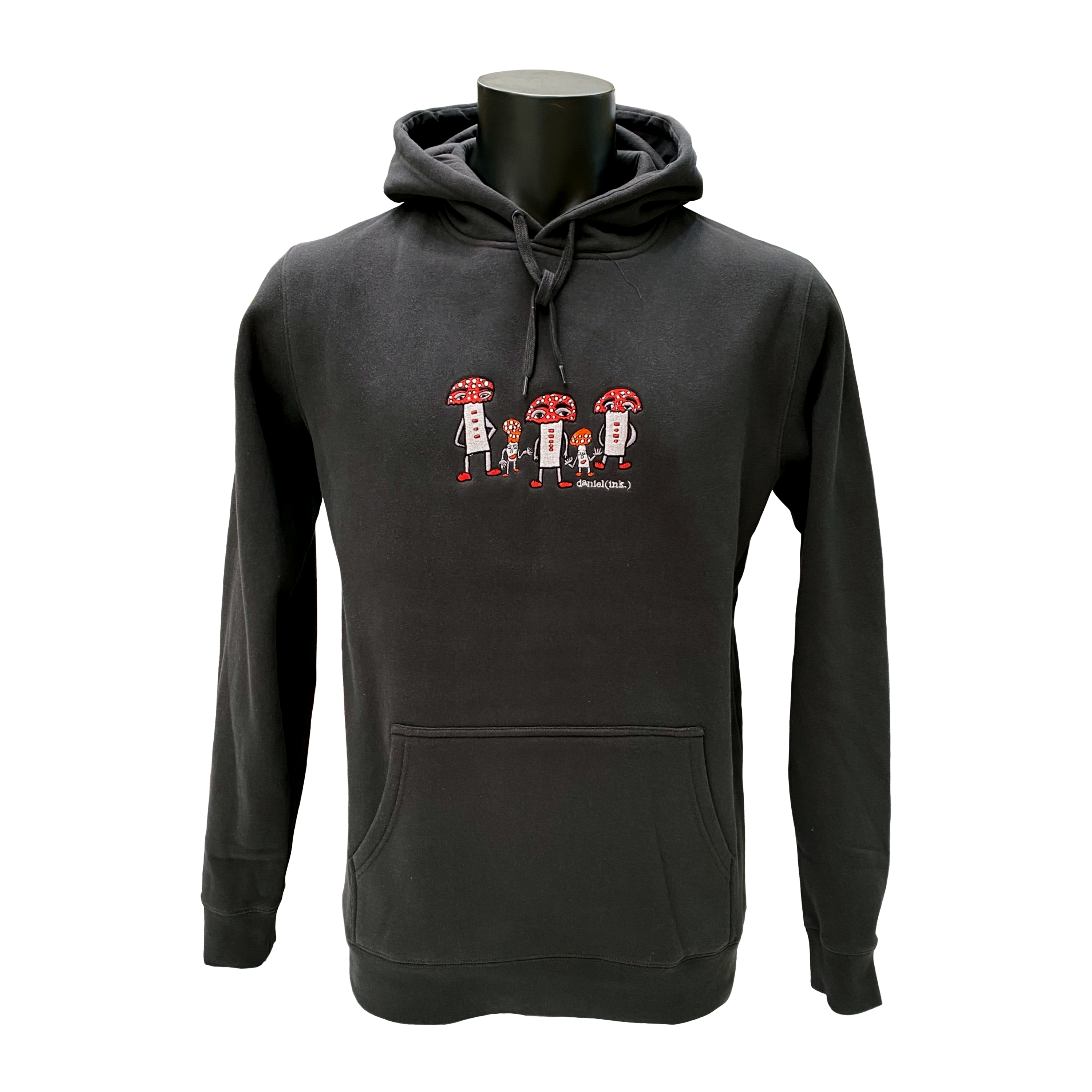 Unisex coal coloured hoodie featuring an embroidered image of five humanoid mushroom figures, three large and two small, standing next to each other. Each mushroom figure has a red mushroom cap, red shoes, and red accents. The three large mushrooms also have red buttons on their chests which spell "magic" in Morse code. The name daniel(ink.) is embroidered in silver thread underneath the mushroom people.